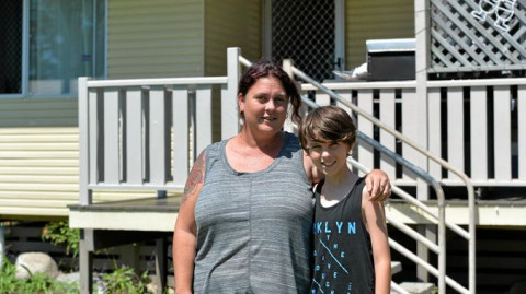 Single mother Anne Heel and her son Christopher in front of their Queensland house