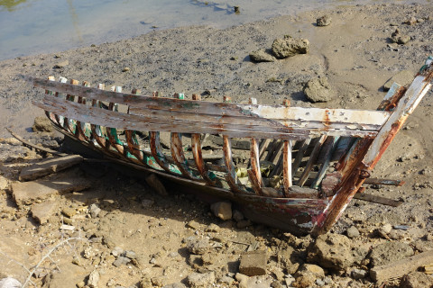 derelict boat on sand at low tide