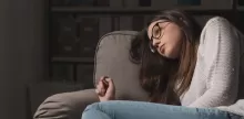despondent girl leaning on sofa