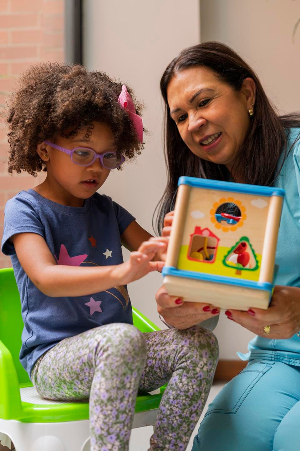 Physiotherapist doctor performs exercises to her patients sensory therapy girls.