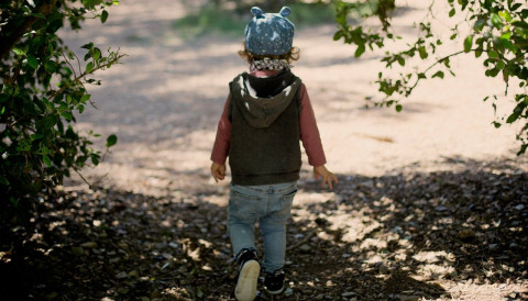 child walking away in tree shadow