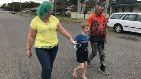 mother, child and father walking down a road