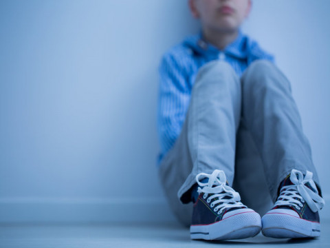 boy sitting against wall