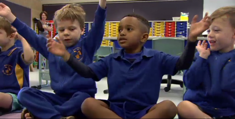 kids sitting with arms held out sideways