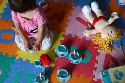 child, a doll and play tea-cups