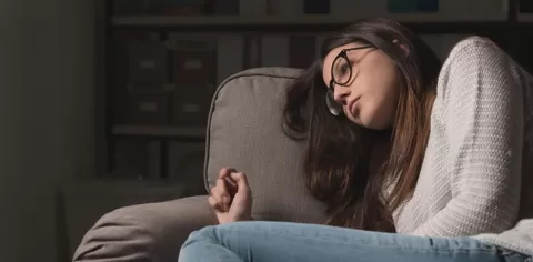 despondent girl leaning on sofa