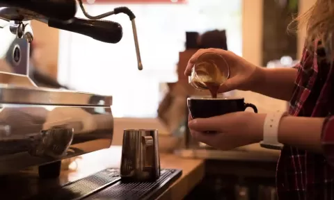 hands makinbg coffee at a coffee machine