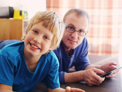 boy and man (with iPad) looking at camera