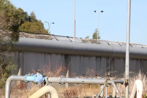 metal prison wall with barbwire on top