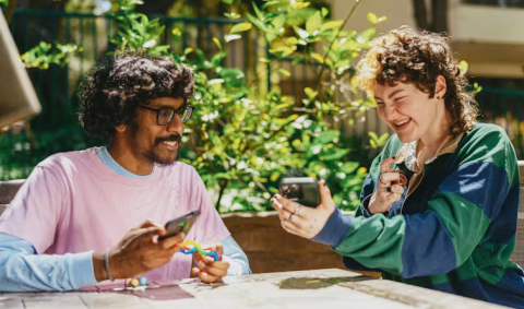 man and woman sitting at table in garden and happily conversing