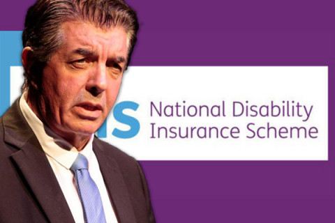 Minister Williams in front of NDIS logo