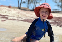 Mitchell Fielke is non-verbal but loves tactile surfaces such as the water and sand. (Supplied: Catherine Fielke)