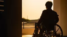 siloette - man in wheelchair looking outside