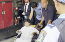 police wheeling a boy in hospital gown sitting in a wheelchair