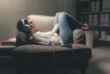 woman lying on sofa with noise-cancelling headphones