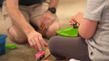 boy and man playing with wooden toy train