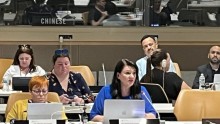 Moniue speaking in room of people